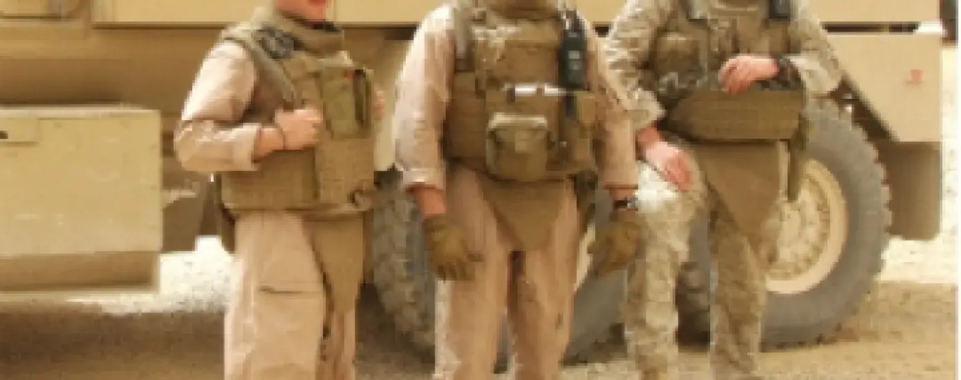 Tom Doucette (far right) with his Iraq team members in front of the truck that hit an IED bomb.