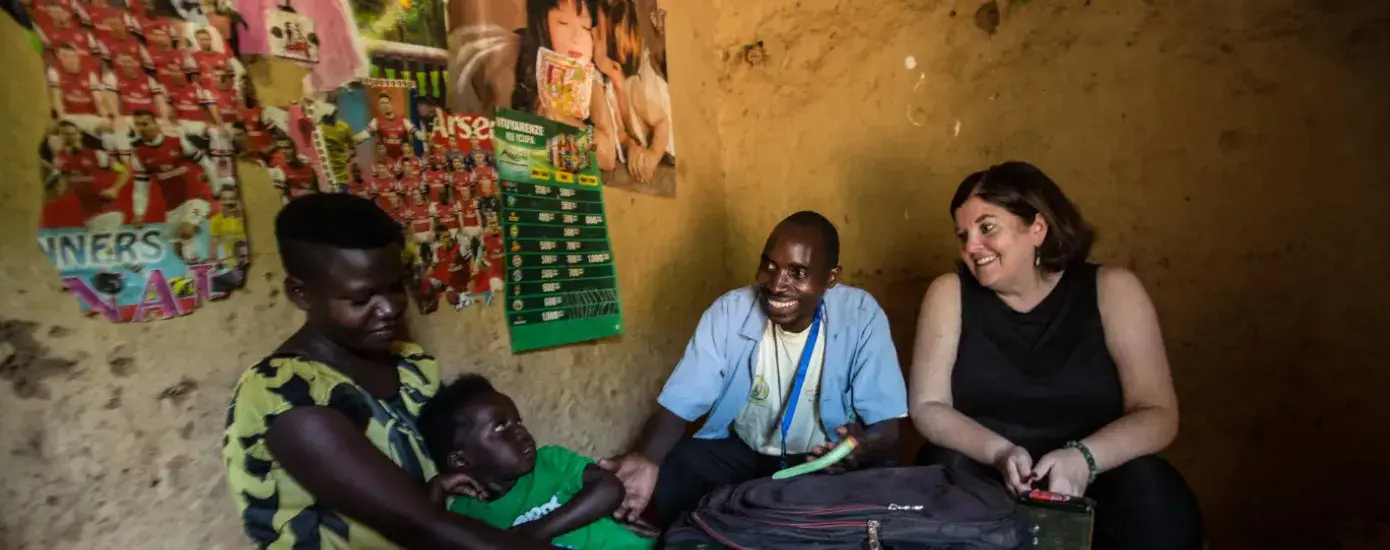 Sheila Davis sits at a table in a concrete room with a Black man, woman and child