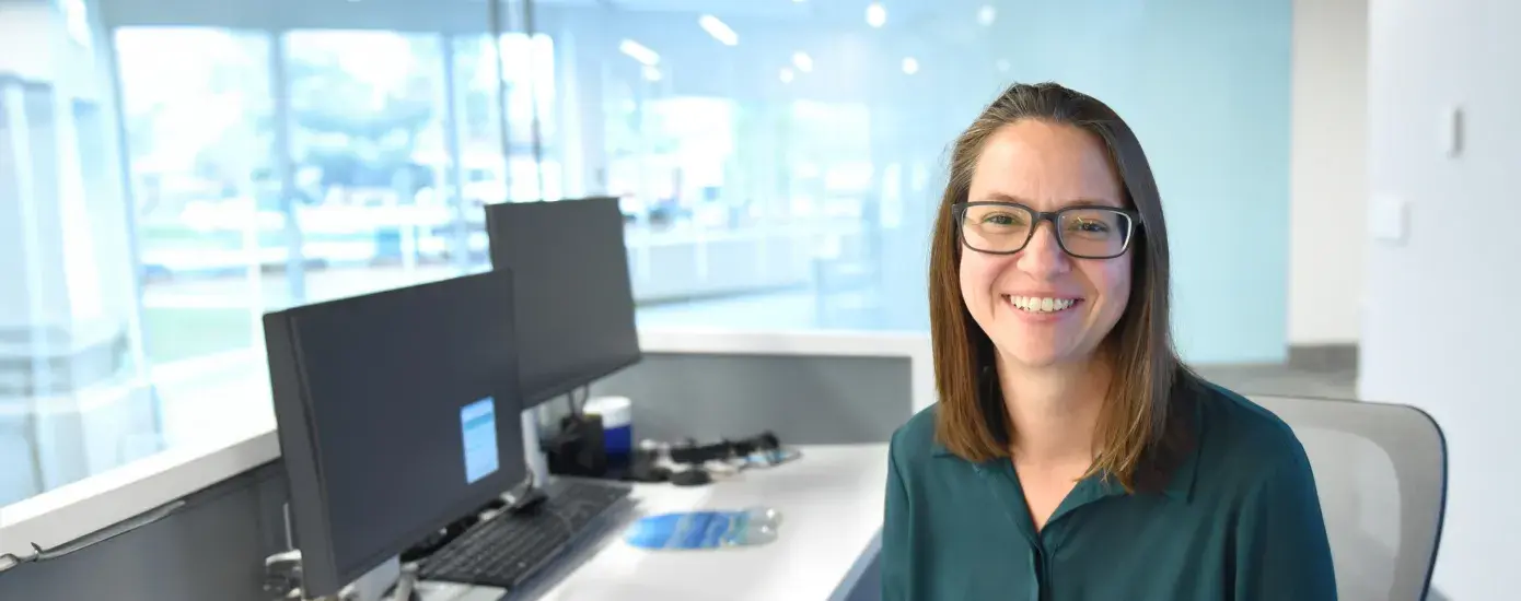 Woman sits at desk and smiles