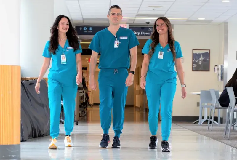 Three nursing students in scrubs walking in  MGH corridor