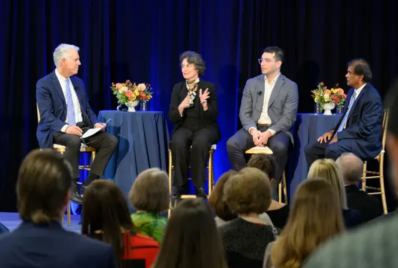 4 people speaking on a stage