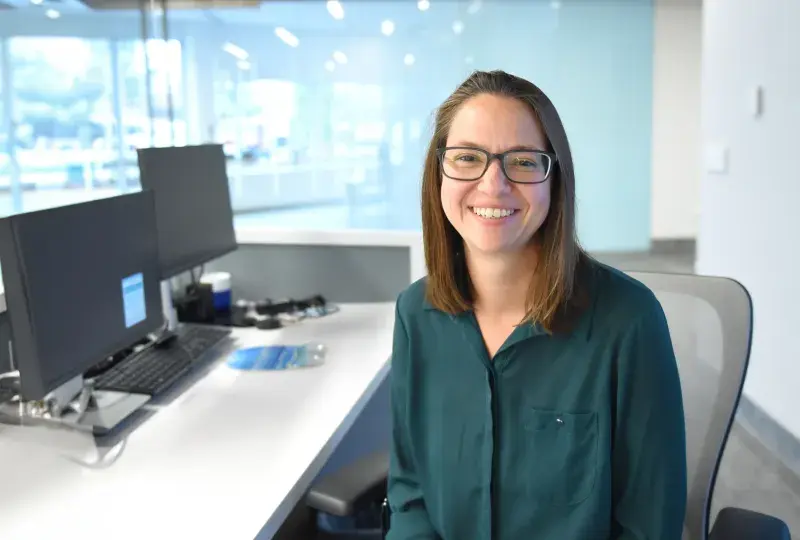 Woman sits at desk and smiles