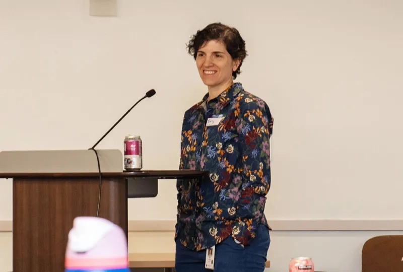 Emily Rosen stands at a podium moderating a panel 