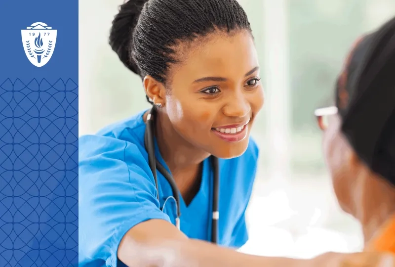 Nurse wearing blue scrubs and a stethoscope around neck putting her hand on shoulder of patient.