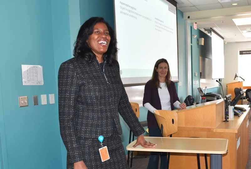 president jones stands and smiles in front of a classroom of students