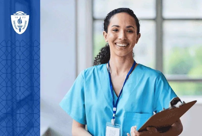 Nursing wearing blue scrubs holding a clipboard and wearing a lanyard around her neck