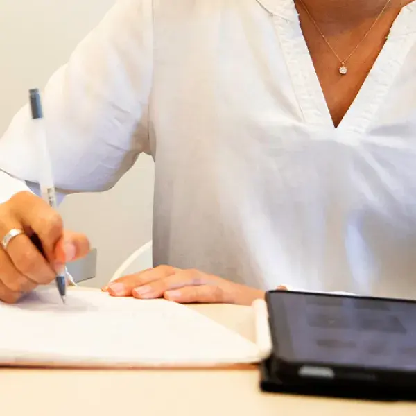 hands write with a pen on a pad