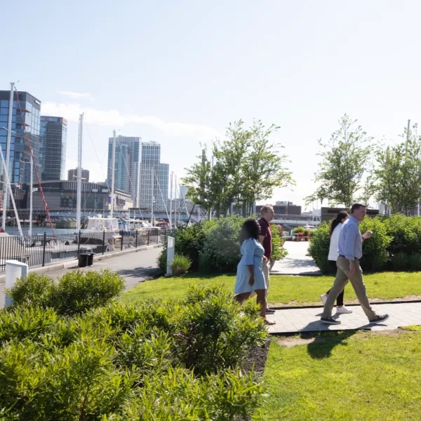 People walking in a park with the waterfront in the background