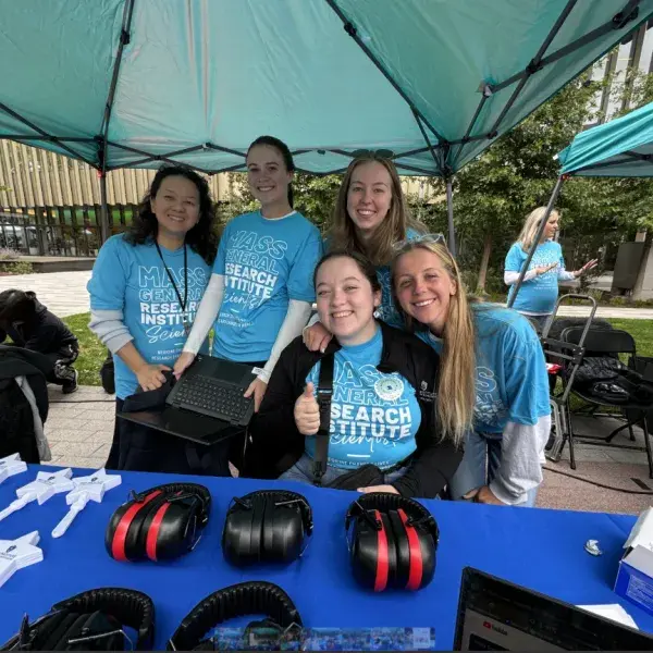 5 women at a booth with headphones on the table