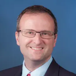 daniel wears rectangular glasses in this profile shot