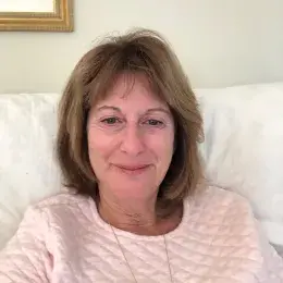 Woman sitting on couch with light pink top