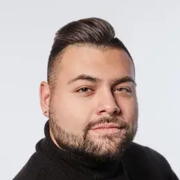 john wears a black turtleneck and has a close cropped beard