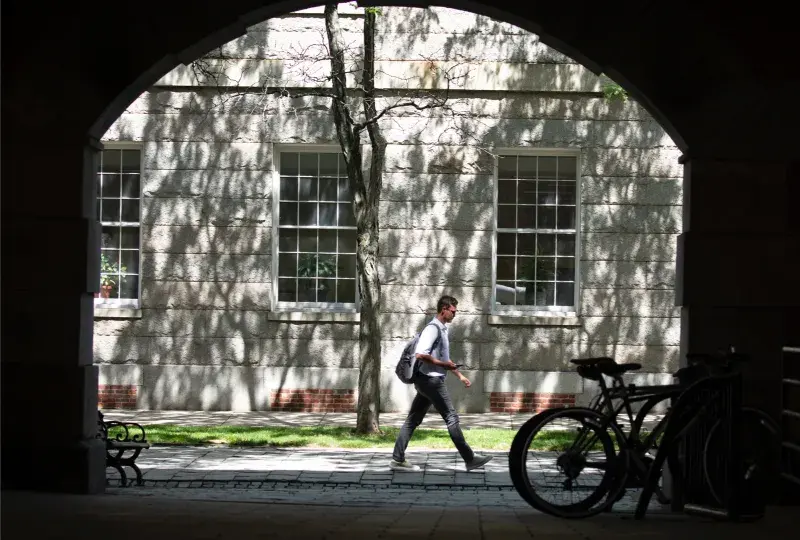 A person walking with a building behind them