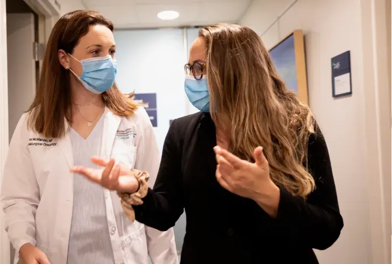 Two nurses having a conversation wearing masks