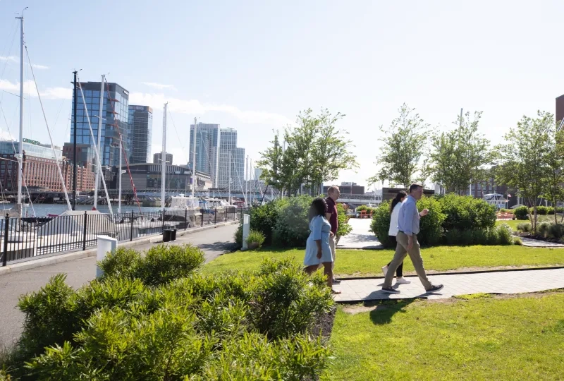 People walking in a park with the waterfront in the background