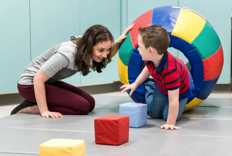 A woman and a young boy playing with blocks