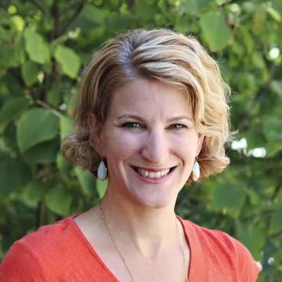 Headshot of an MGH IHP faculty member for the Doctor of Audiology program, outdoors with a natural background.
