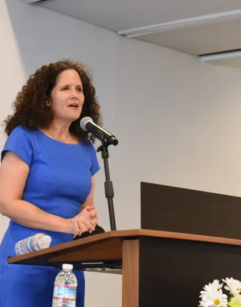A woman speaks at a podium