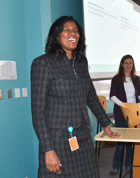 president jones stands and smiles in front of a classroom of students