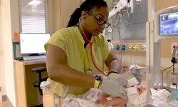 A student nurse in the Fast-Track BSN Program performing a newborn assessment as part of the accelerated nursing curriculum. This intensive nursing training focuses on preparing students for nursing licensure through hands-on experiences in a high-paced clinical environment.