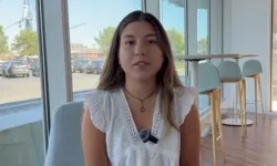 woman speaks in front of a window